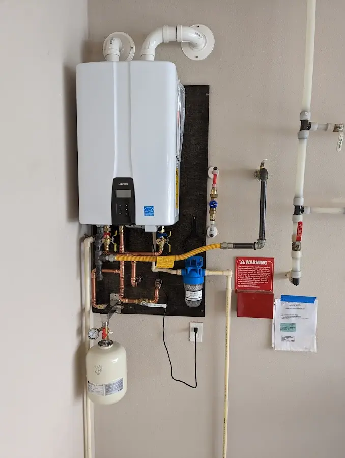 Professional plumber installing copper piping in a Elmwood home